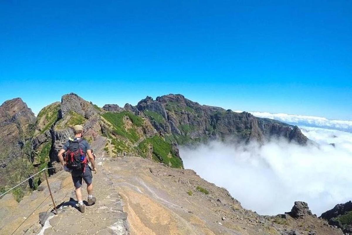 čovjek koji stoji na vrhu planine
