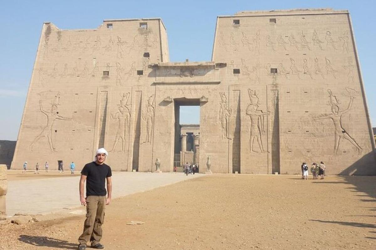 a man is standing in front of an ancient building