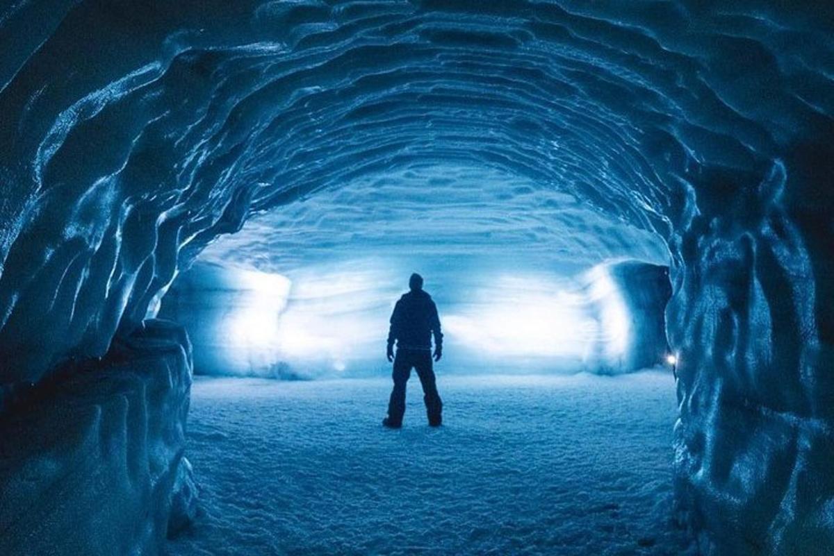 Maður stendur í göngum í íshelli