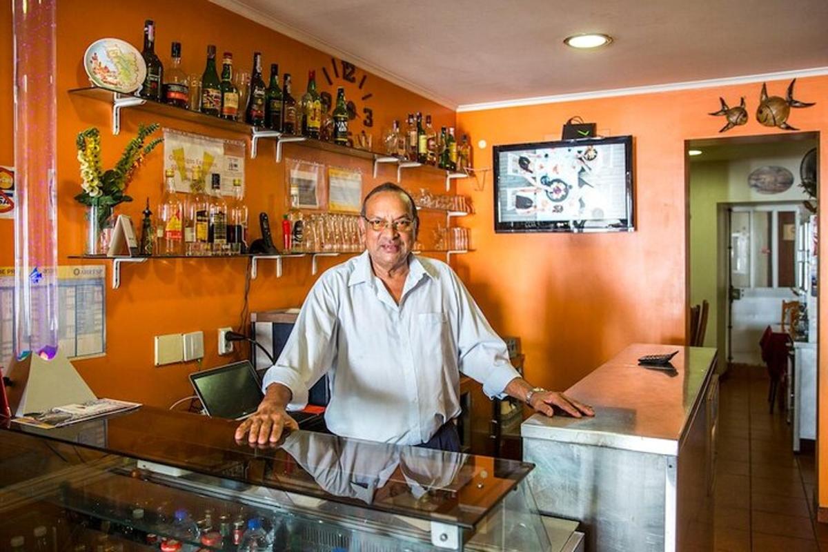 seorang lelaki berdiri di kaunter di sebuah bar