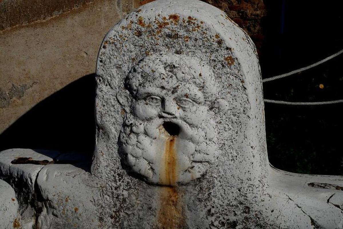 ένα τσιμεντένιο άγαλμα ενός κεφαλιού με στόμα