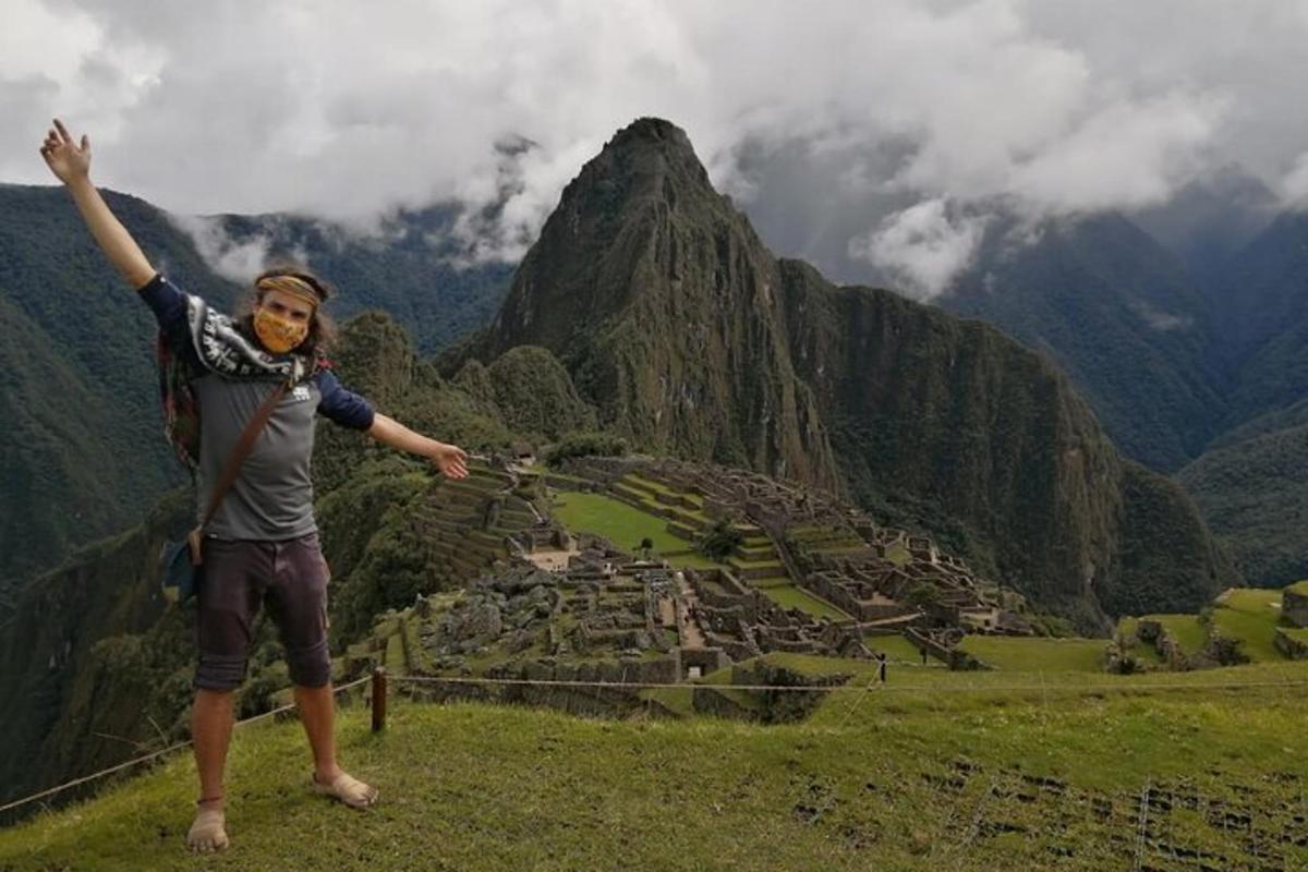 a woman standing on top of a mountain with her arms up