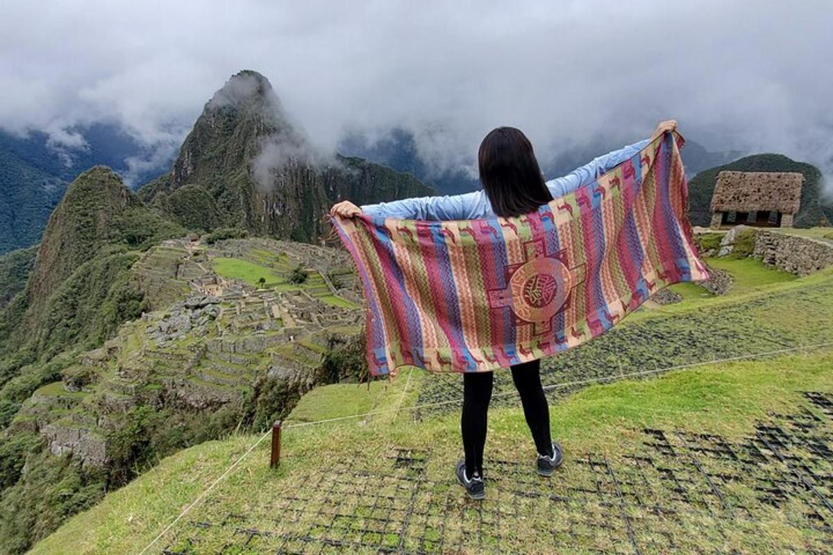 seorang wanita berdiri di atas bukit sambil memegang selimut