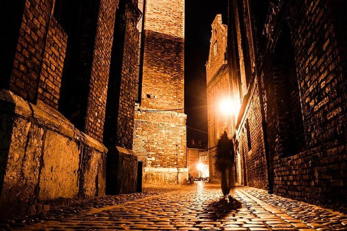 una persona caminando por un callejón de noche