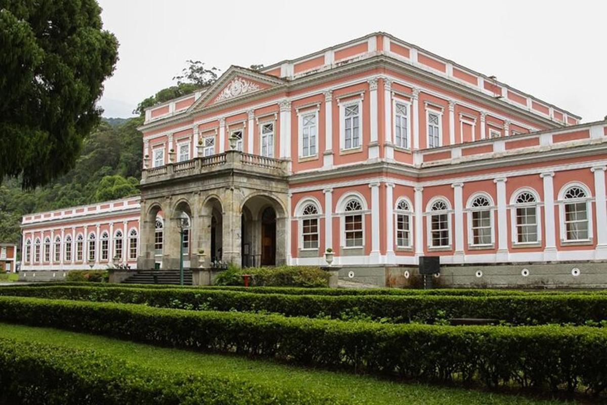 veľká ružová budova so záhradou pred ňou