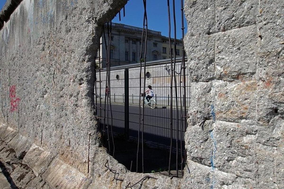 isang taong naglalakad sa isang gate sa isang batong pader