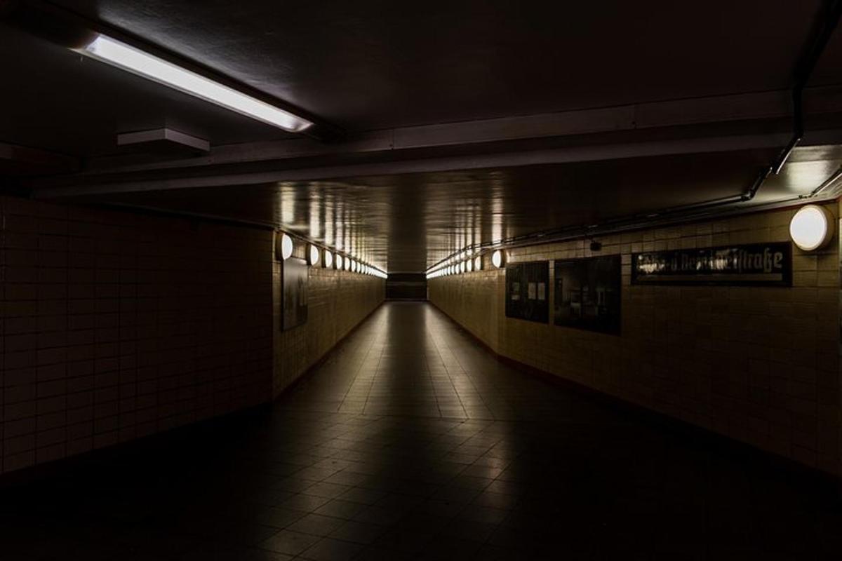 a dark hallway of a subway with a long tunnel