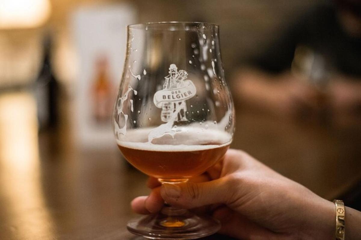 a person is holding a glass of beer
