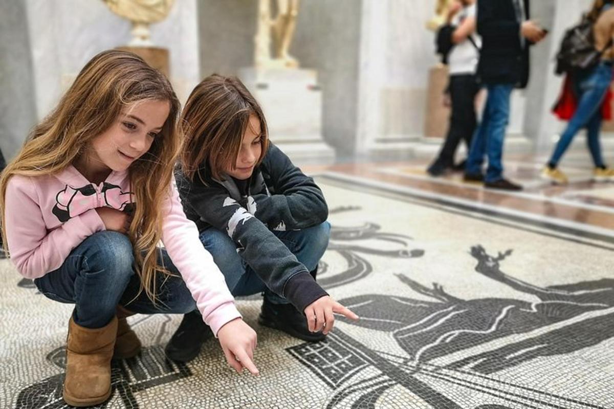 deux jeunes filles regardent un dessin sur le sol d'un immeuble