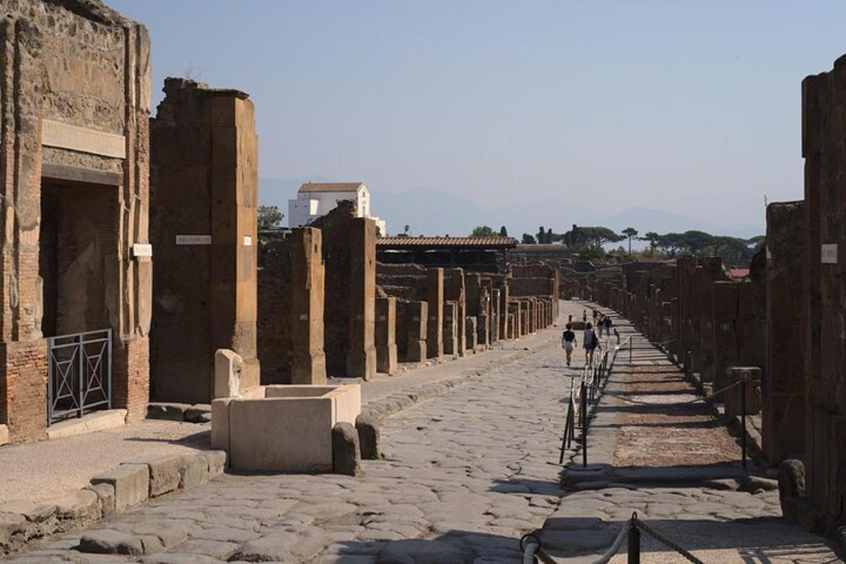 due persone camminano lungo una strada tra le rovine