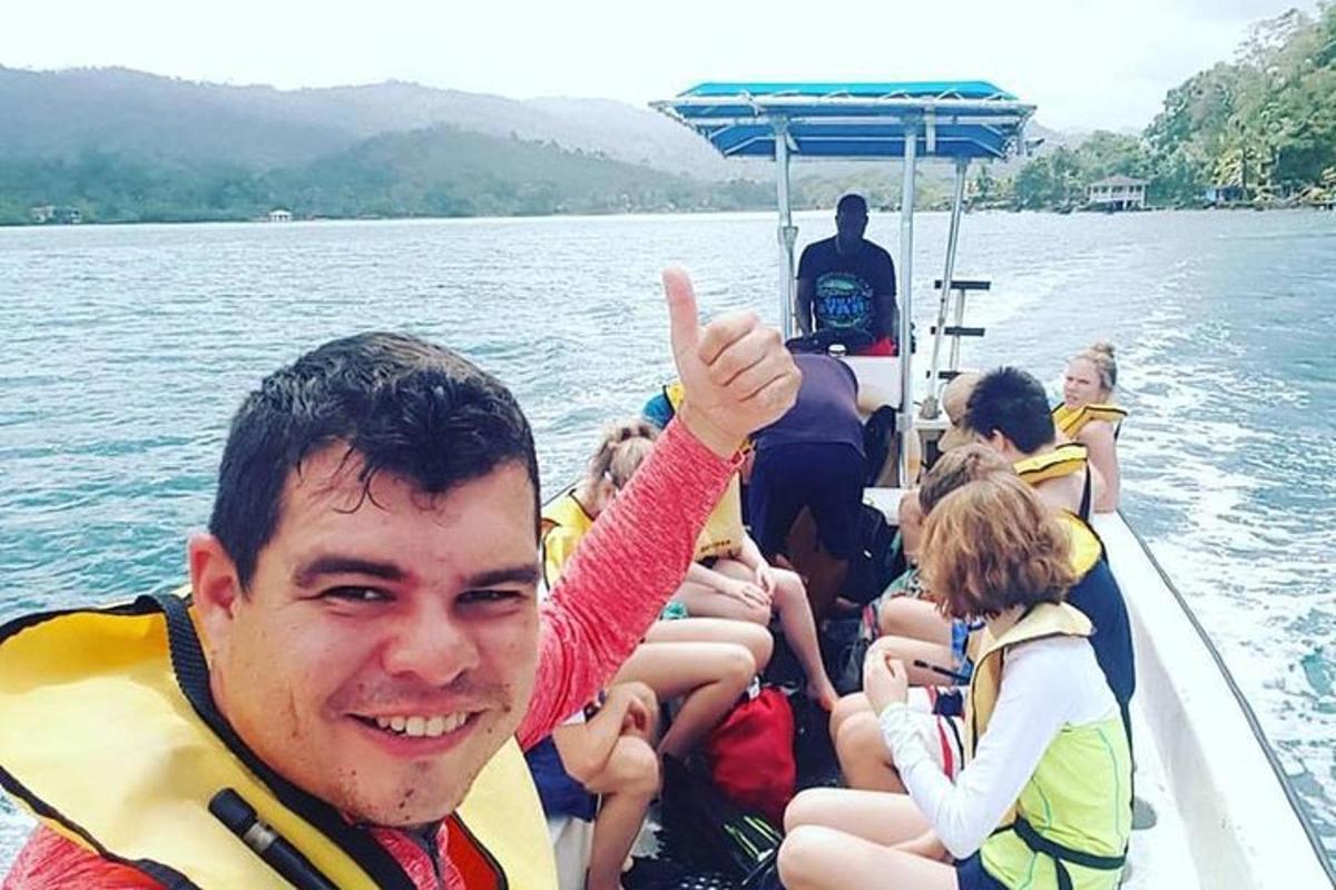 un uomo che fa il gesto del pollice in su su una barca