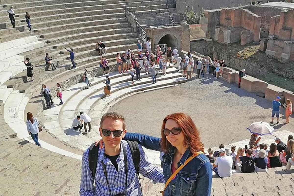 a man and woman standing in front of a amphitheater