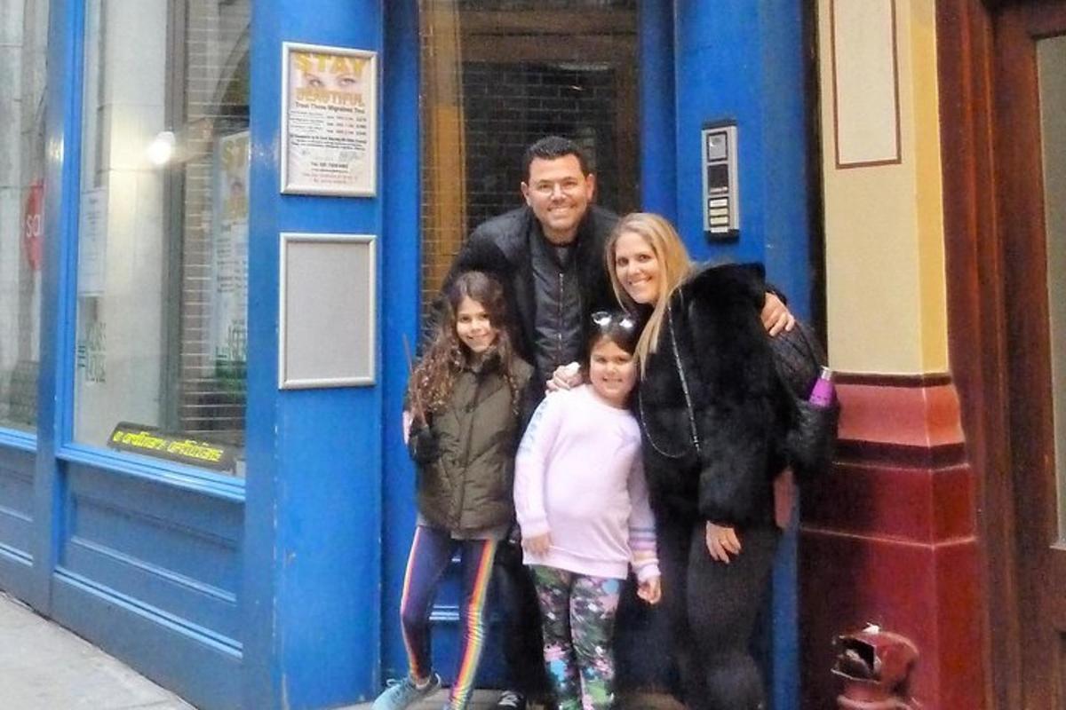 un uomo e due bambini in piedi davanti a una porta