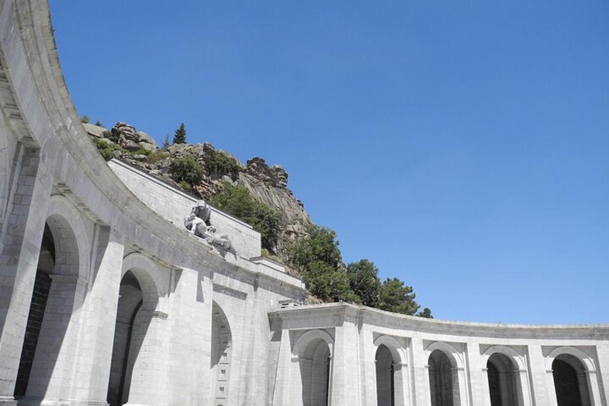 Un gran edificio con una colina al fondo.