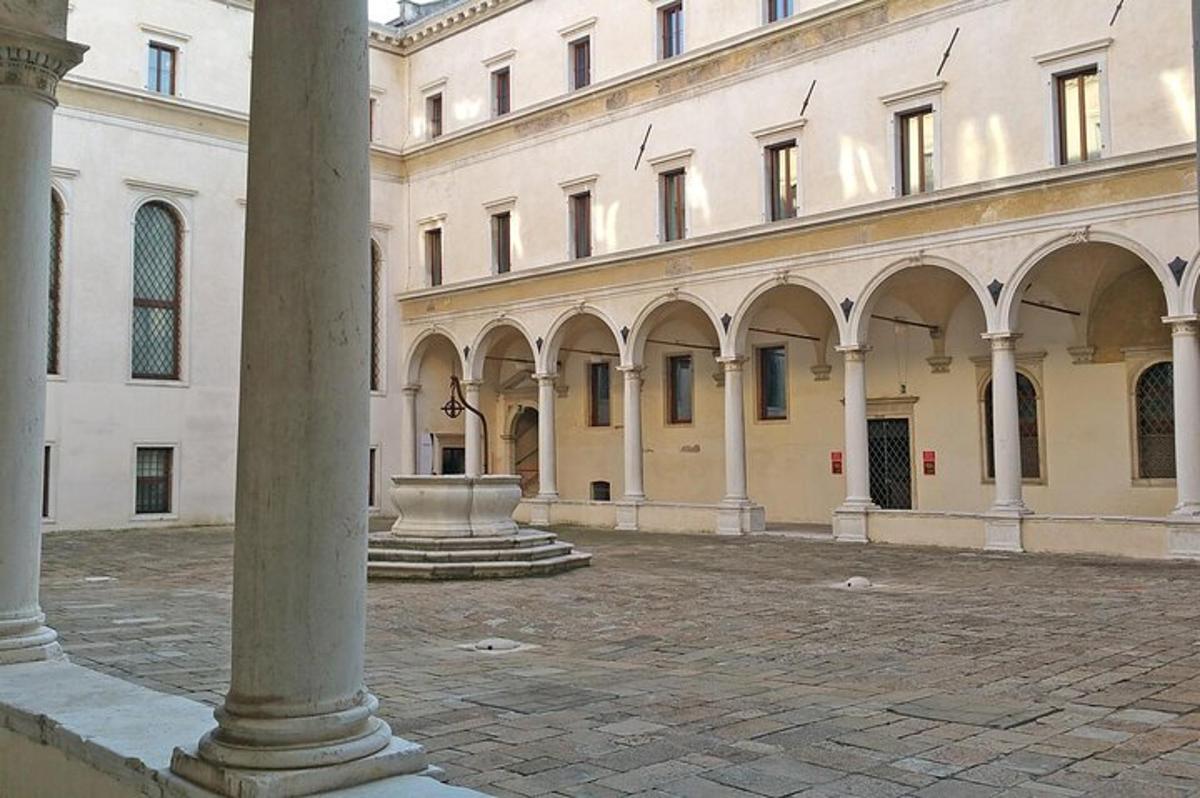 un grande edificio con una fontana in un cortile