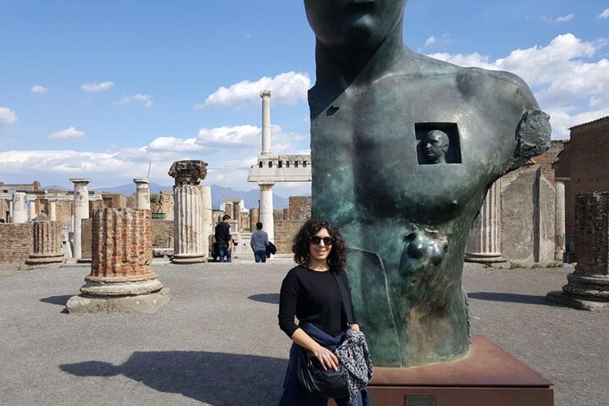 una donna in piedi davanti a una statua
