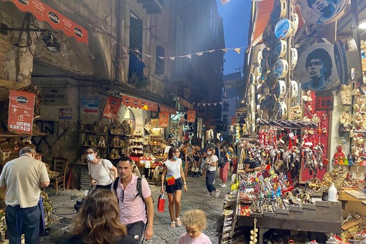 um grupo de pessoas caminhando por um mercado em uma rua