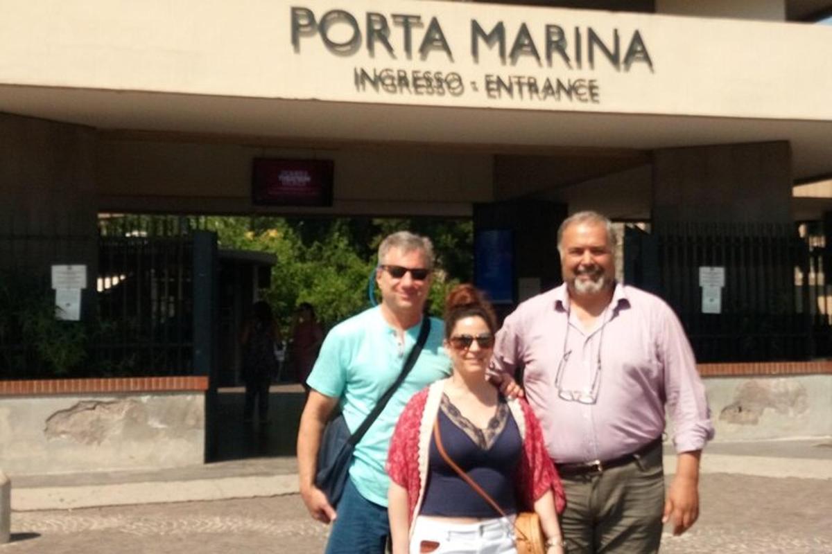 un gruppo di tre persone in piedi davanti a un edificio