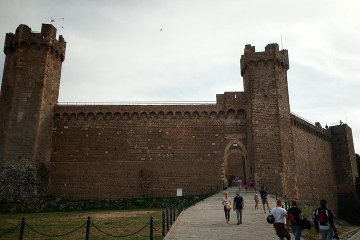 persone che camminano davanti a un grande edificio in mattoni