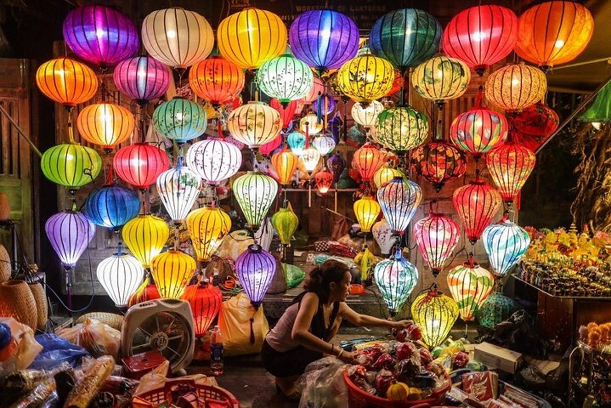 una donna seduta davanti a un mercato con luci colorate