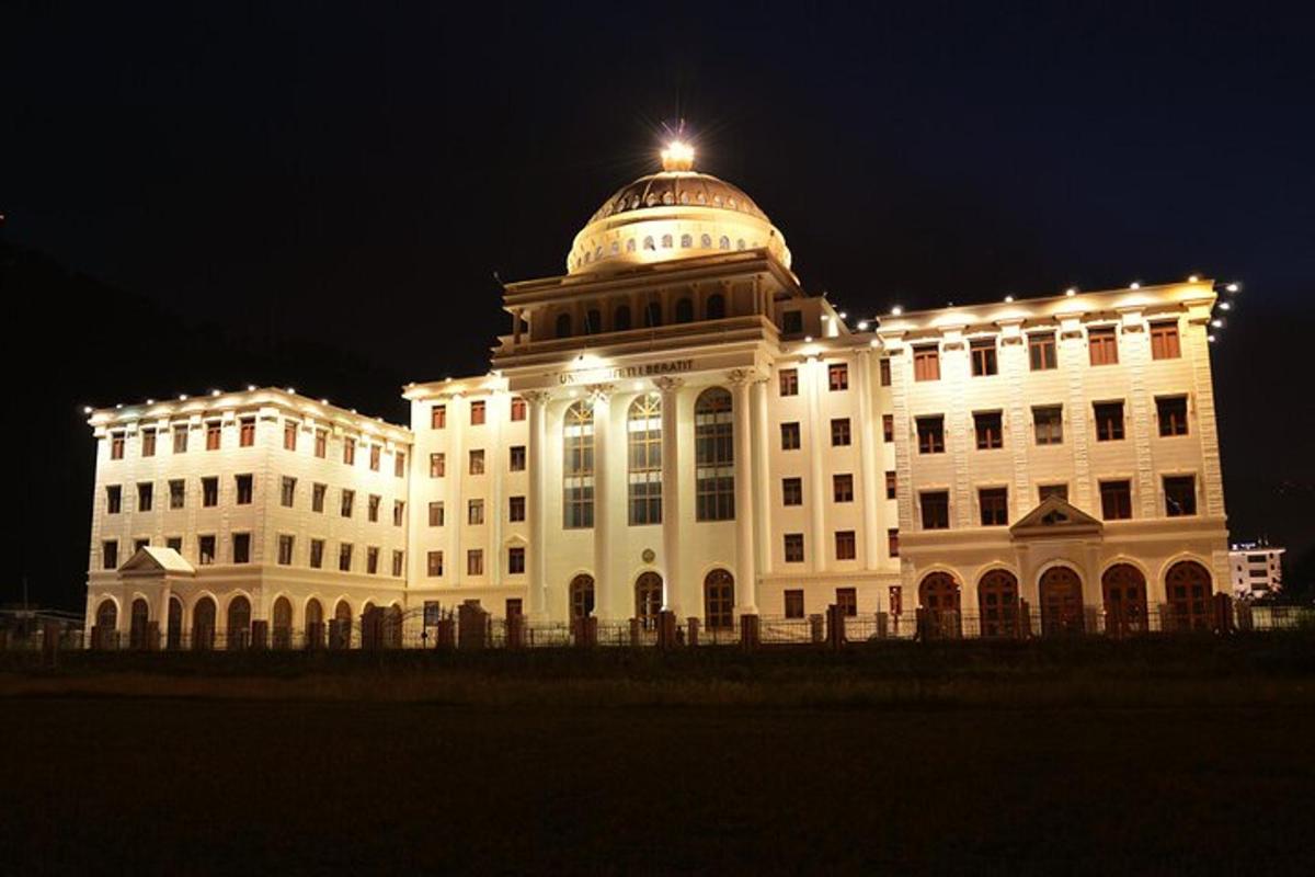 Un gran edificio blanco con una cúpula en la parte superior por la noche.