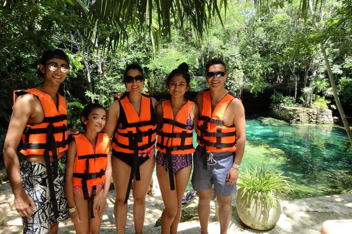 un grup de persones amb armilles salvavides taronges dretes al costat d'una piscina