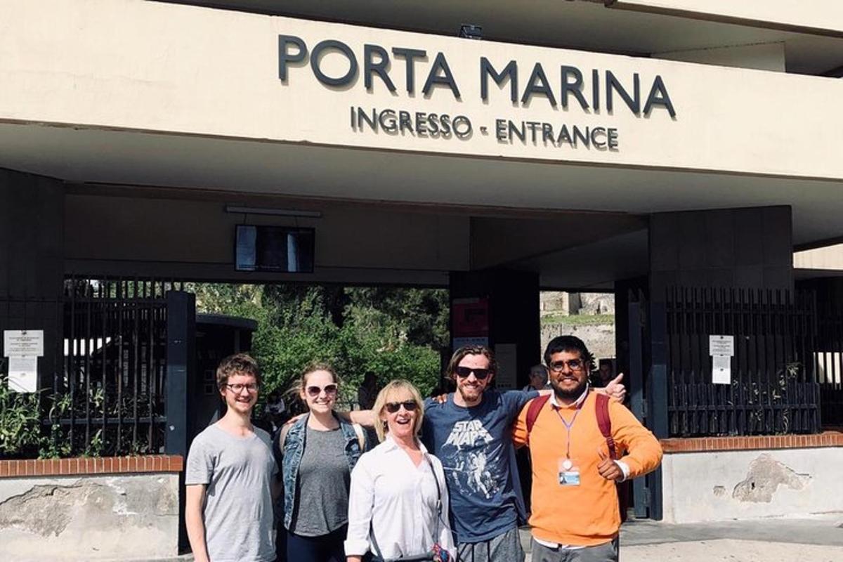 un gruppo di persone in piedi davanti a un cartello