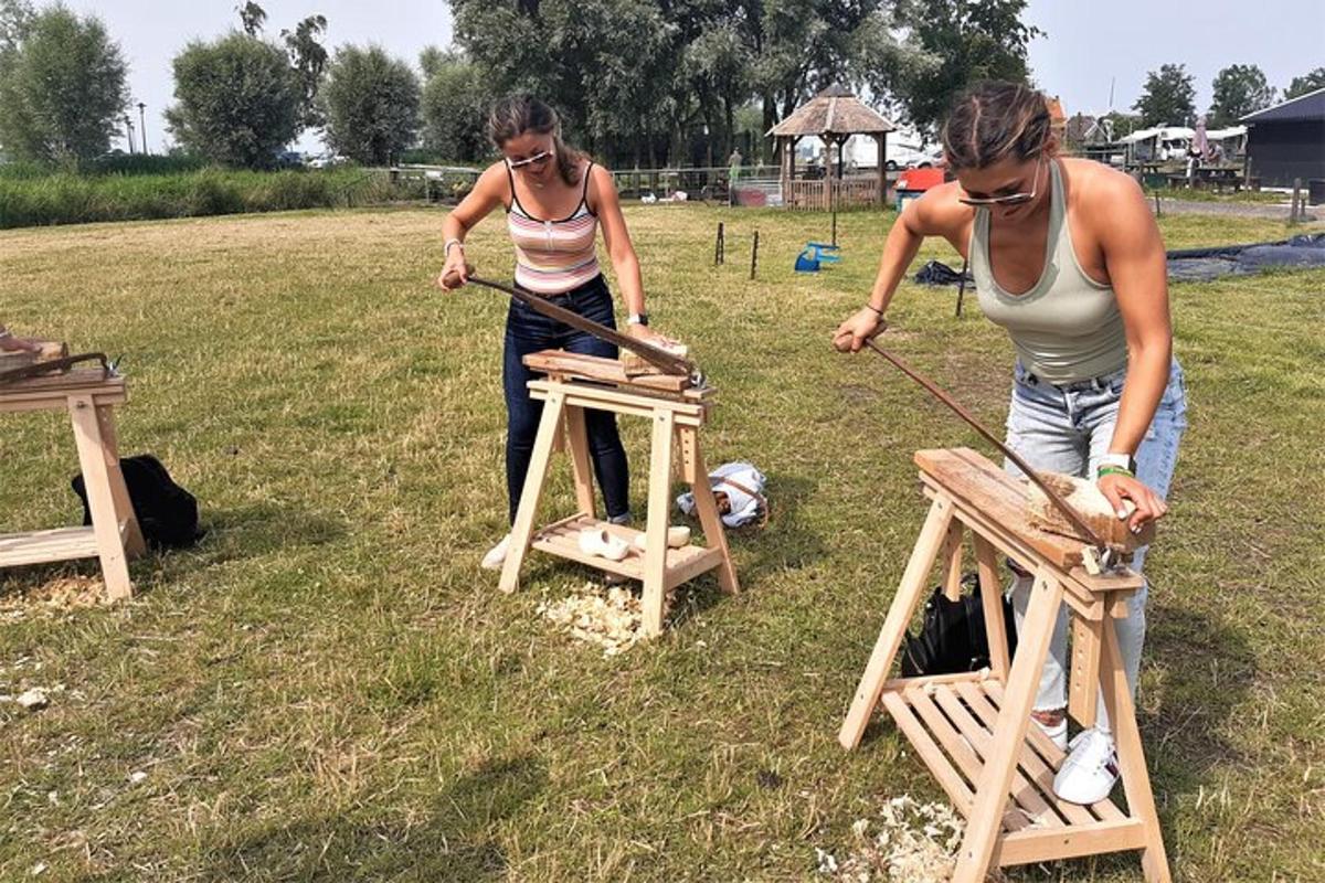 Dvě ženy staví dřevěné stoličky na poli