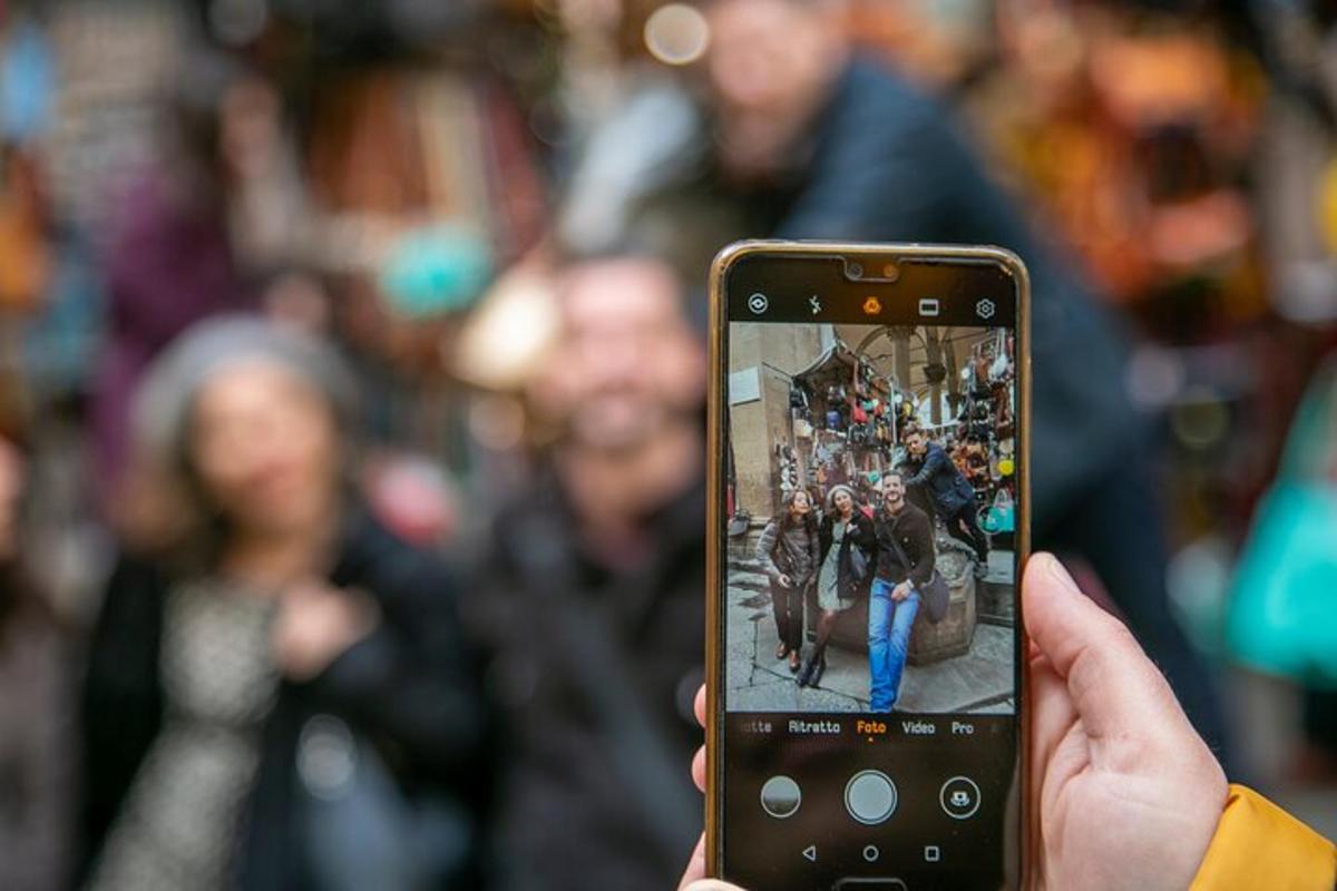 una persona que sosté un telèfon mòbil per fer una foto