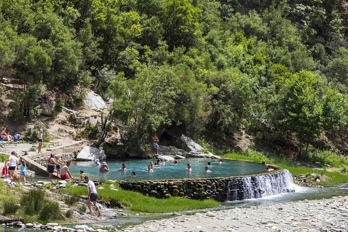 a group of people in a swimming pool with a waterfall