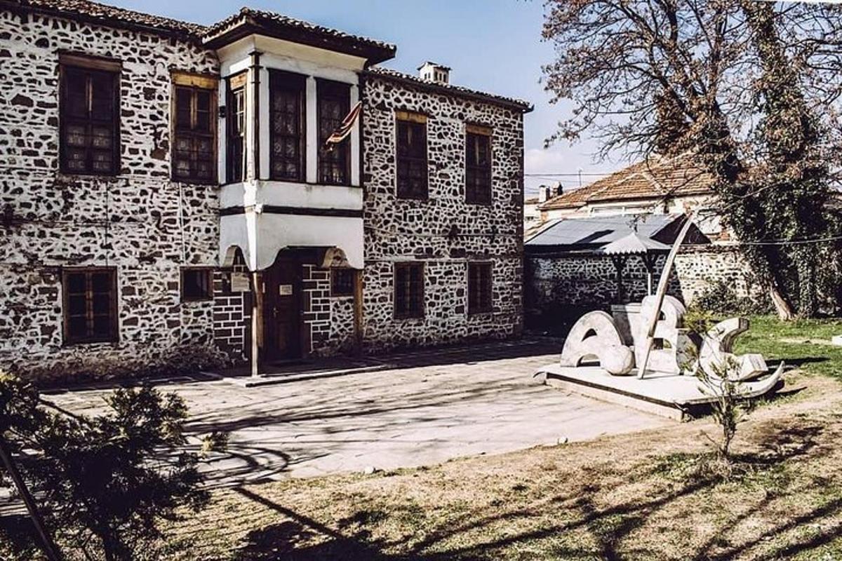 una casa di pietra con una statua di fronte