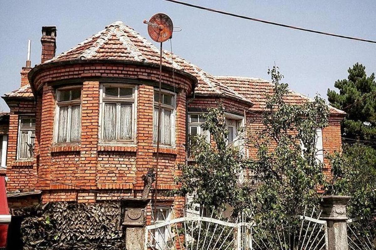 una vecchia casa di mattoni con un orologio in cima