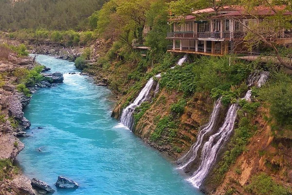 a house on a hill next to a river