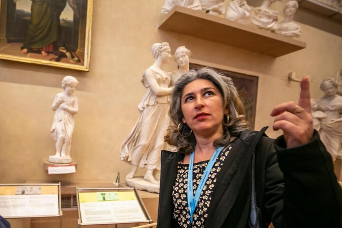 seorang wanita menunjuk ke arah patung di muzium
