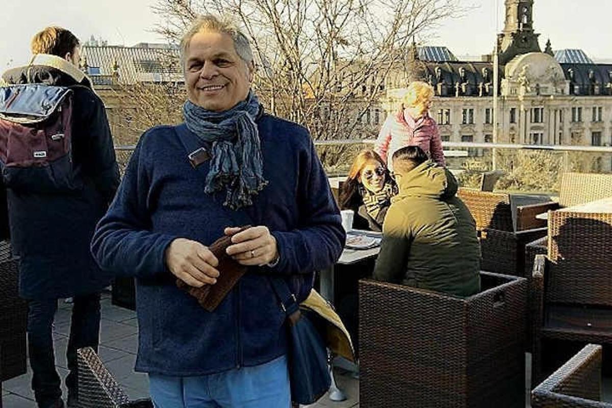 Ένας άντρας που φοράει ένα μαντήλι και στέκεται δίπλα σε μια ομάδα ανθρώπων