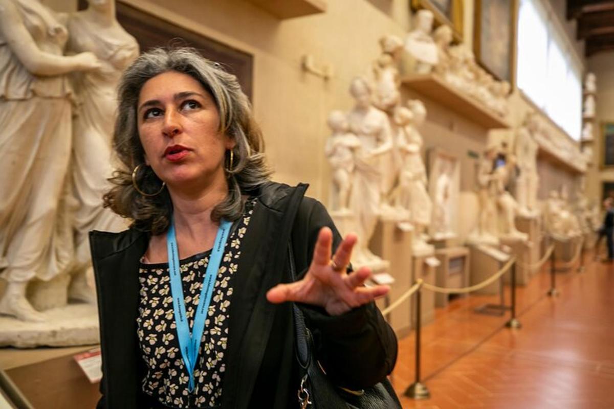 Una mujer parada en un museo señalando una estatua.