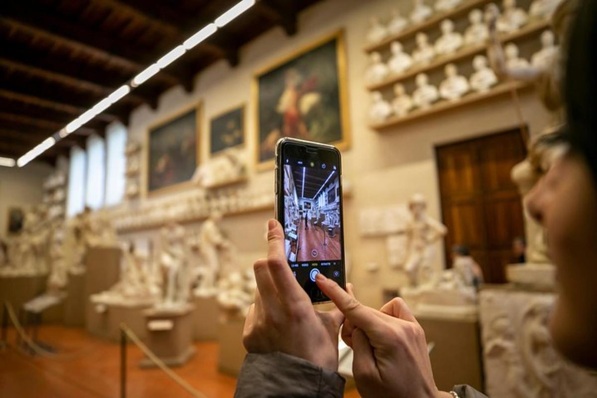 een vrouw die met haar mobiele telefoon een foto van een sculptuur maakt