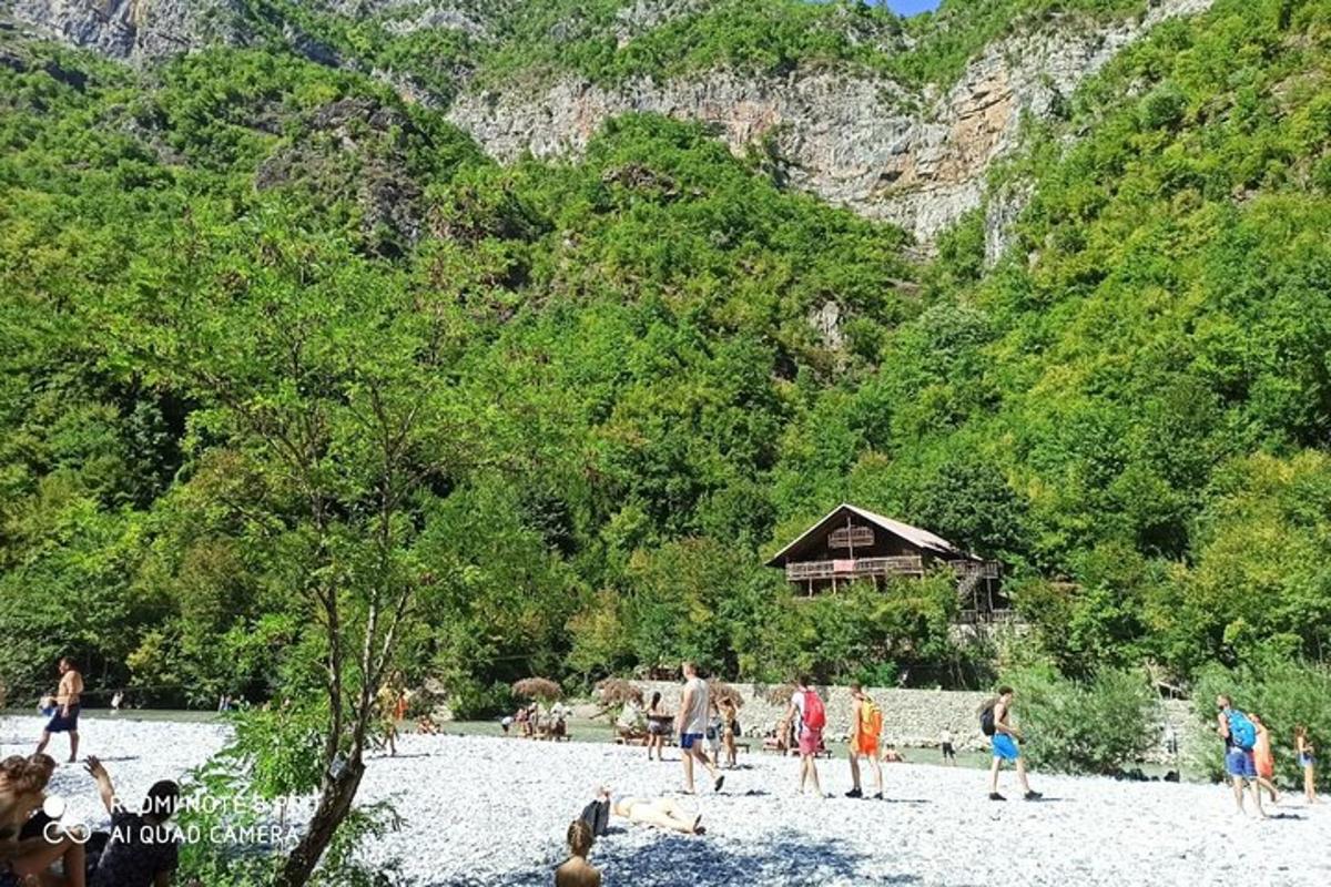 a group of people on a beach near a mountain