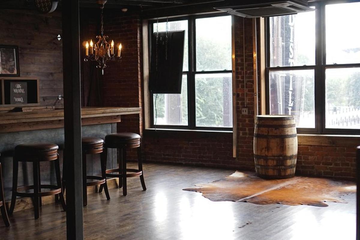 a room with a bar with stools and a barrel