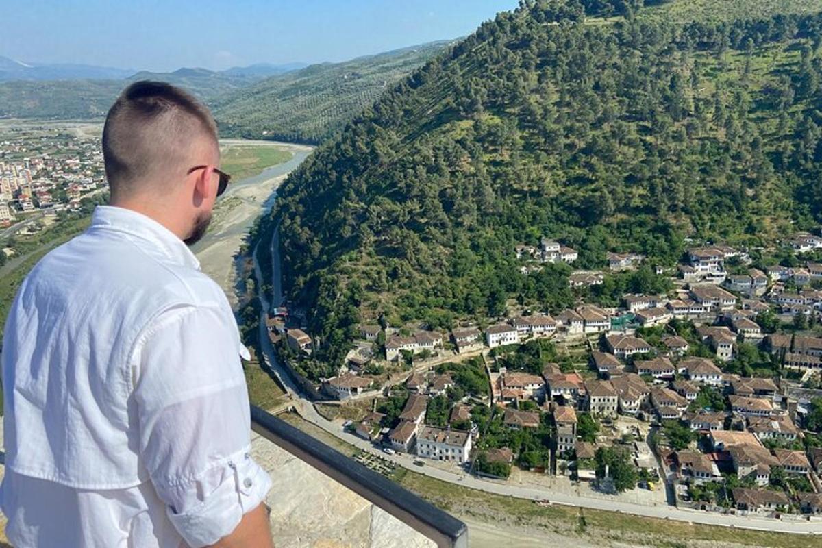 a man standing on a ledge looking down at a city