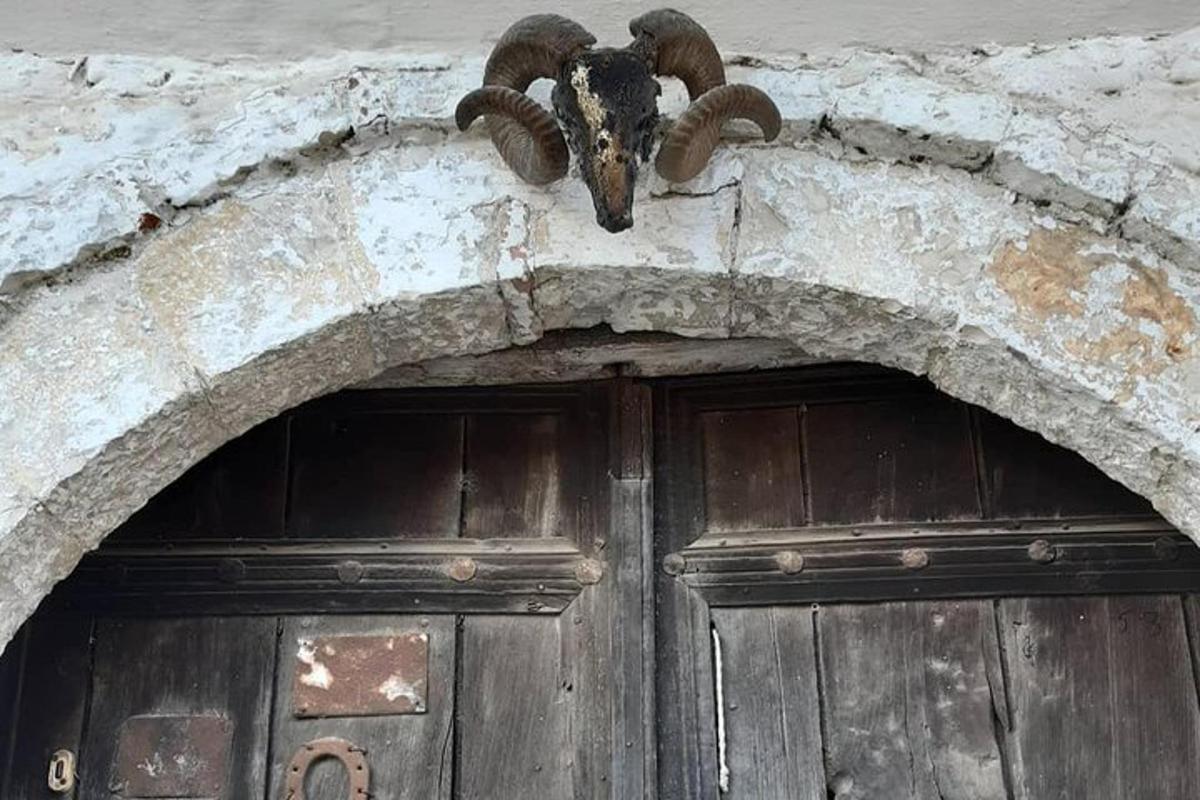 un edificio con una porta con una testa di capra sopra