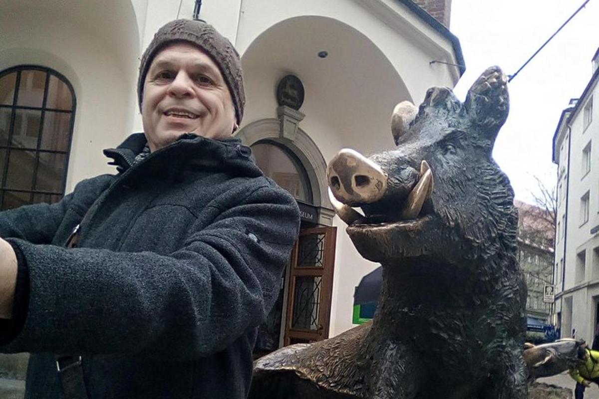 un bărbat care stă lângă o statuie a unui elan