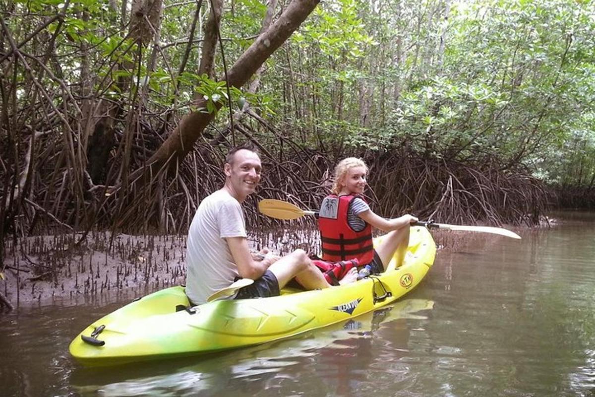 isang lalaki at isang babae na nakaupo sa isang dilaw na kayak sa tubig