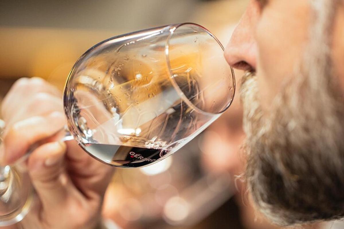 a man drinking a glass of red wine