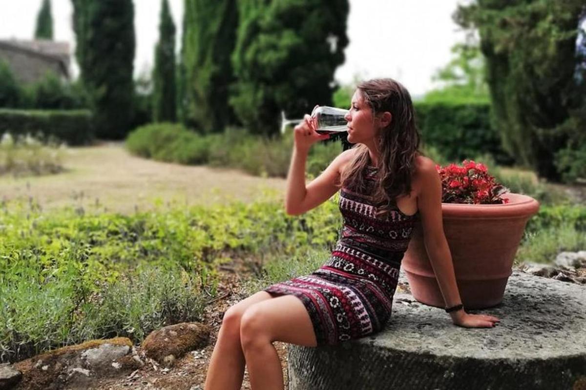 žena sediaca na skale a fotiaca fotoaparátom
