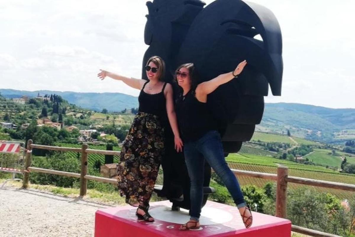 due donne in piedi accanto alla statua di un orso
