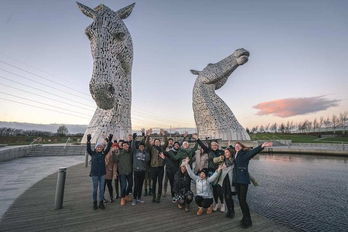 en gruppe mennesker står foran en girafstatue