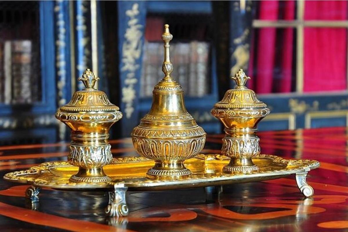 dalawang gintong urns na nakaupo sa ibabaw ng isang mesa