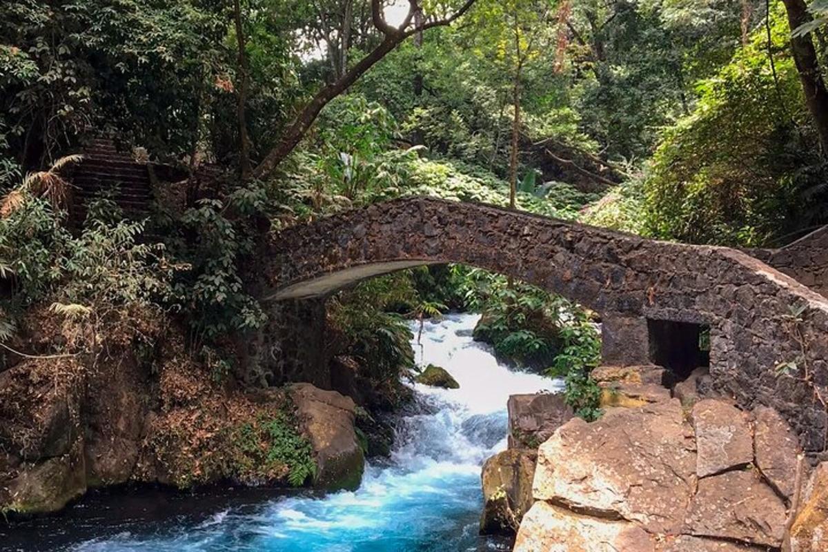 a stone bridge over a river with blue water