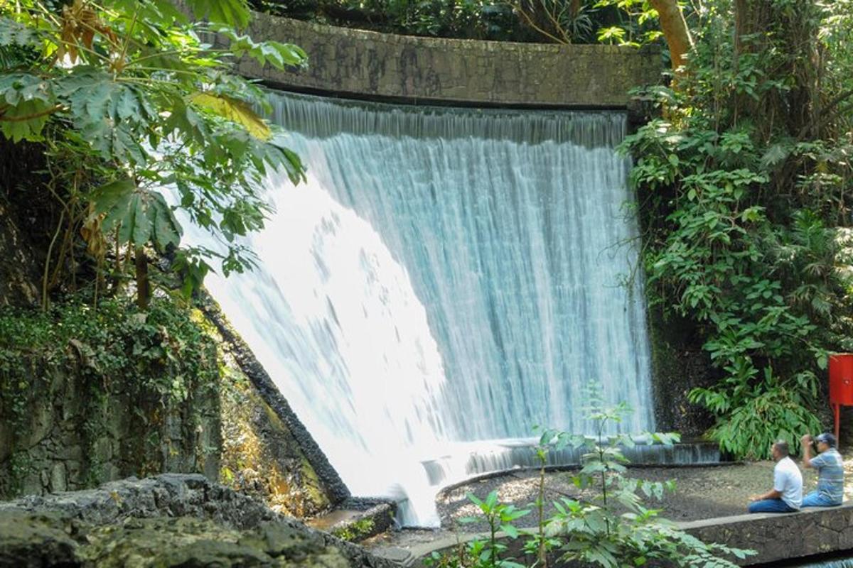 two people sitting in front of a waterfall